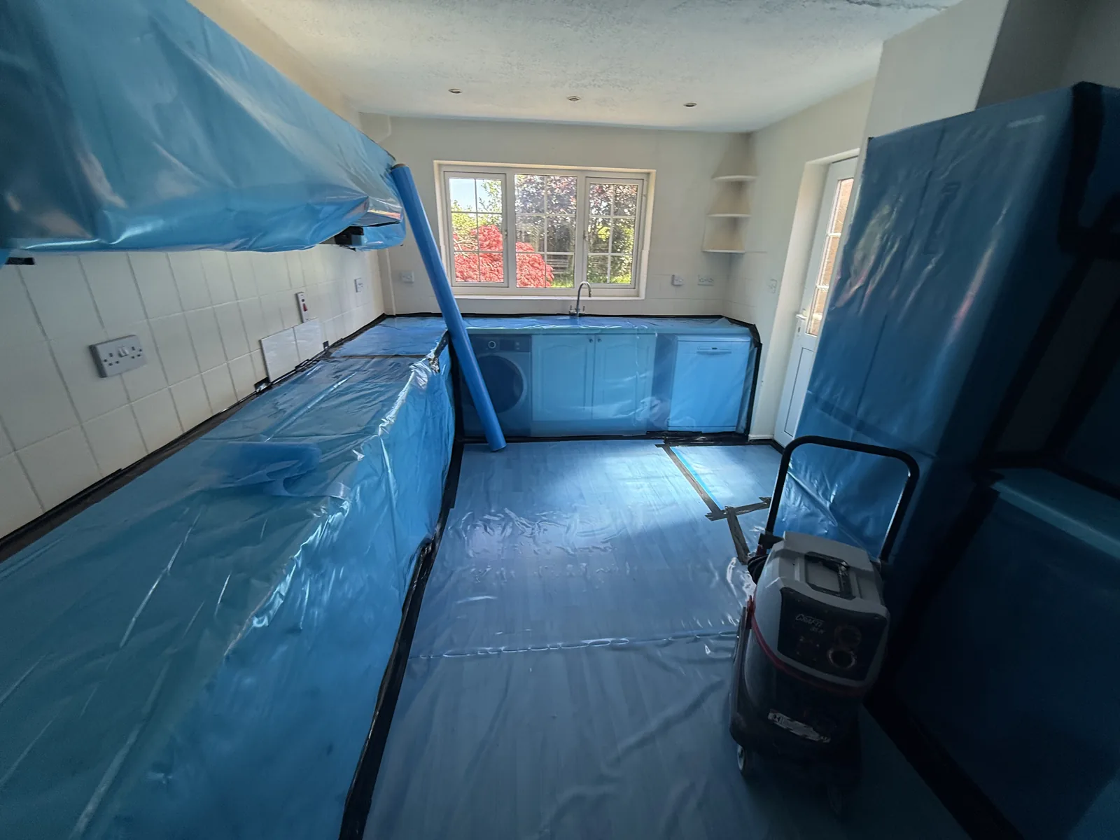 Kitchen protected with sheeting in preparation for ceiling removal