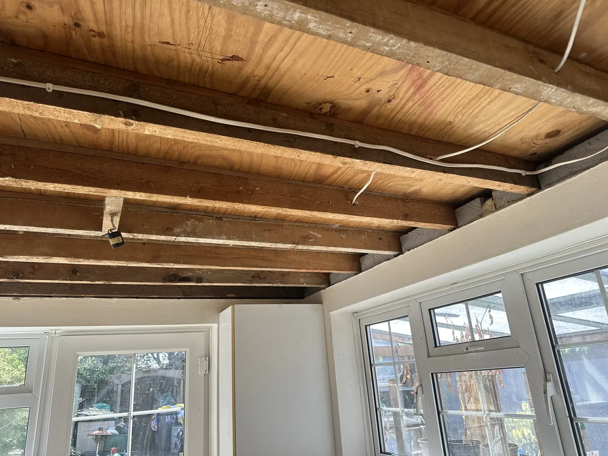 The same room with timber joists exposed after ceiling removal
